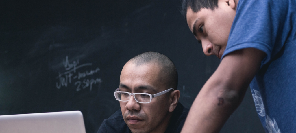 coworkers_in_front_of_blackboard-1440×650