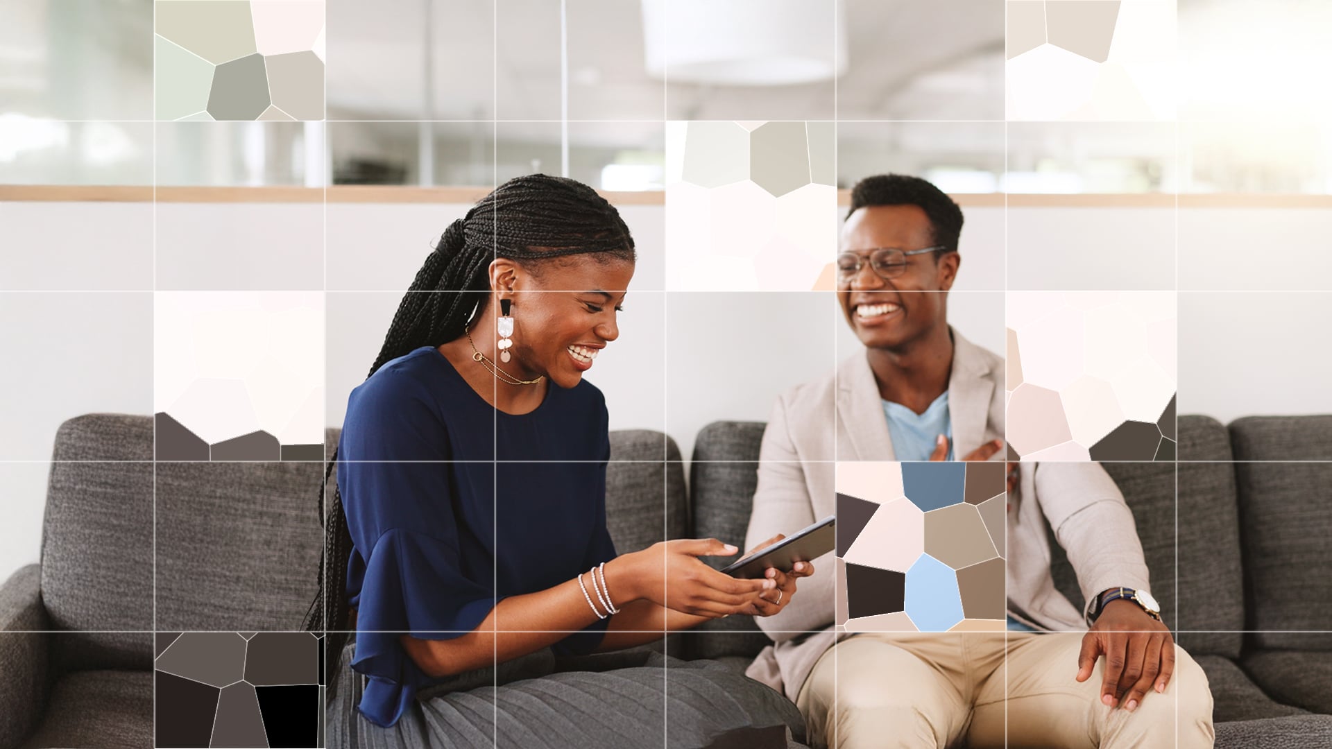 Two people smiling on sofa with smart phone